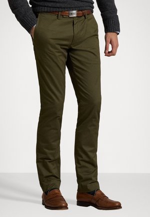 Chinos verde oliva con un diseño de pierna recta, lazos para cinturón con un cinturón de cuero marrón y una textura de tela suave.