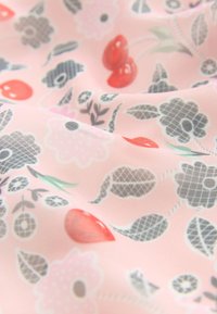 Rosa tyg med ett blommönster i grått, vitt och rött, med blad, kronblad och små röda knoppar på en mjuk, slät yta.