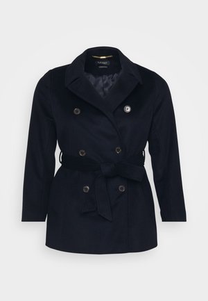 Cappotto doppiopetto blu navy con colletto a punte, cintura legata, due tasche frontali e bottoni metallici. Tessuto morbido con una fodera interna liscia.