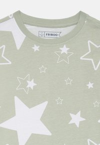 Grünes Baumwoll-T-Shirt mit weißem Sternenmuster, runder Ausschnitt und kurzen Ärmeln. Etikett zeigt Größe 9/10, 134/140 cm.