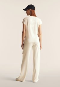 Freddy CON BORCHIE E SCOLLO A V - Camiseta estampada - star white