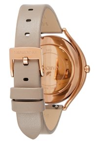 Swarovski-klocka med boett i rosaguld, beige läderrem och en minimalistisk design. Har ett spänne med varumärkesgravyr och en slät yta.