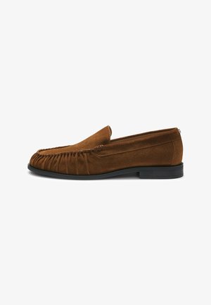Bruna mockaläder loafers med rynkad detalj fram, en slät rund tå och en svart gummisula. Ingen synlig hårdvara eller mönster.