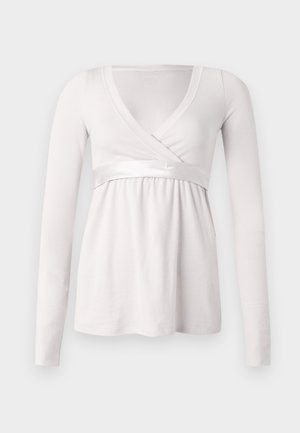 Balta ilgarankovė palaidinė su V formos iškirpte ir užrišamu dizainu. Juosmeninėje dalyje yra lygi satino juosta, o visas audinys turi gofruotą tekstūrą.