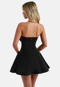 Svart utan axelremmar klänning med en åtsittande liv och utsvängd kjol, med en bakre dragkedja och slät textur.