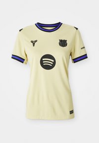 Camiseta de fútbol amarillo claro con un logo negro de Spotify, escudo del club y acentos morados en el cuello y las mangas. Diseñada con una textura suave.
