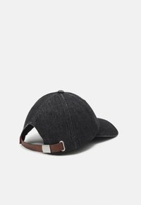 Gorra de mezclilla negra con corona redondeada, visera curvada y cierre de correa de cuero marrón con ajustador de metal en la parte posterior.