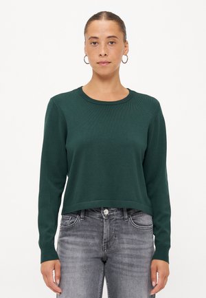 Groene gebreide trui met een ronde halslijn en lange mouwen, met een cropped zoom en geribbelde manchetten, gecombineerd met grijze jeans.