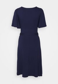 Mörkblå klänning i mjukt tyg, med puffärmar, en figurnära bodice och en utsvängd kjol med ett midjebälte för struktur.