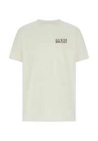 T-shirt en coton couleur crème avec un col rond, des manches courtes, et un petit logo marron sur la poitrine à gauche. Coupe simple et classique.
