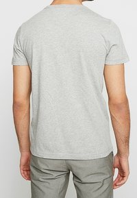 Harmaa crew-neck t-paita, joka on valmistettu puuvillasta, lyhyet hihat, yksinkertainen pinta ilman näkyviä kuvioita tai koristeluja.