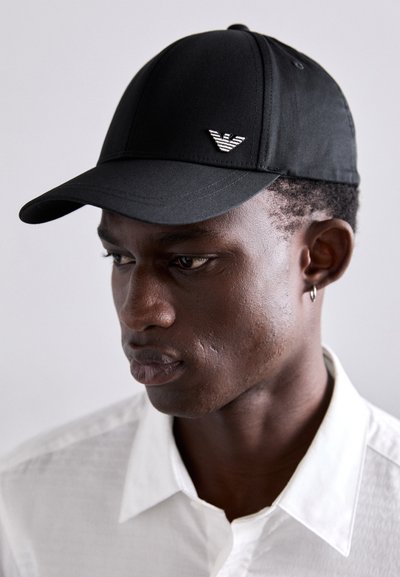 Casquette de baseball noire avec un design structuré, présentant un logo en relief à l'avant et une texture de tissu lisse.