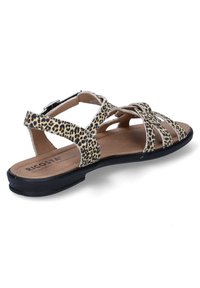 Sandály s leopardím vzorem, s několika zkříženými pásky, černou podrážkou a hnědou stélkou. Disponují bočním přezkou pro nastavitelnou velikost.