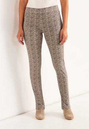 Gestrickte, grau und braun gemusterte Hose mit Slim-Fit, weichem Stoff und elastischem Bund, kombiniert mit hellbeigen Knöchelschuhen.