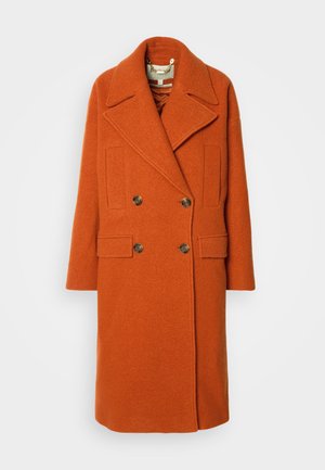 Dubbelzijdige oranje wollen jas met een brede opstaande kraag, twee voorzakken en knopen in goudtint. Gestructureerde stof en een relaxte pasvorm.
