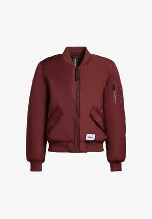 Burgundi bomber dzseki cipzáros elülső résszel, bordás mandzsettákkal és zsebekkel. Sima, fényes anyagból készült, egyszínű dizájnnal. Márkás címke az alján.