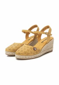 Sandali wedge gialli in pelle con design perforato, cinturino alla caviglia e suola avvolta in juta. Presenta un piccolo accento metallico sul lato.