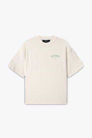 Kremasta pamučna majica kratkih rukava, sa zelenim printom koji glasi "Favela Limited" na lijevom dijelu grudi. Jednostavan, opušten dizajn.