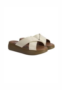 Beige, cross-band slide sandalen met een glanzende afwerking, gestructureerde bovenkant, open teen en een dikke, gebogen bruine platformzool.