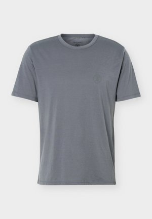 T-shirt da uomo a maniche corte con scollo tondo in blu-grigio spento con un sottile logo rotondo sul petto sinistro su sfondo semplice.