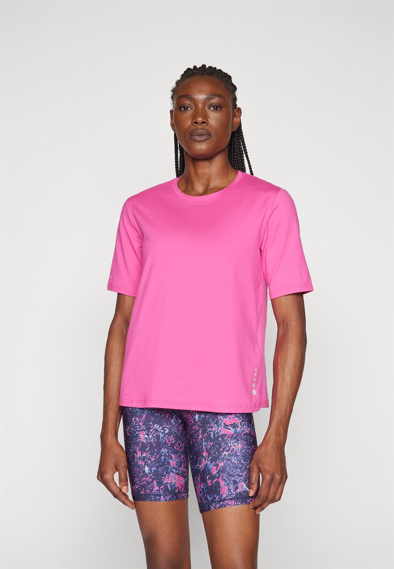 Short-sleeve, pink athletic t-shirt with a round neckline, paired with patterned, navy and pink shorts, featuring a smooth texture and slight sheen.