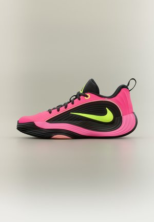 Ярко розов и черен маратонка Nike с неоново жълто лого, текстурирана подметка, черни връзки и таб за издърпване на петата, страничен изглед на едноцветен фон.