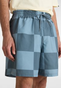 Blaue karierte Badeshorts mit elastischem Bund und Kordelzug. Leichtes Material mit glatter Textur und seitlichen Taschen.