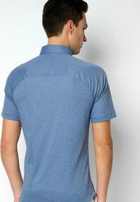 Blaues Polohemd mit kurzen Ärmeln und Knopfkraagen, hergestellt aus einem strukturierten Stoff mit Nahtdetails an Rücken und Schultern.