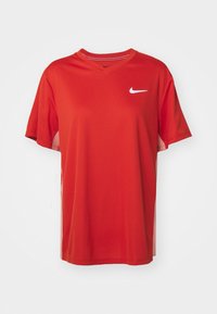 Červené sportovní tričko Nike s krátkým rukávem a výstřihem do V, se bílým logem na levé části hrudníku a hladkým, lehkým materiálem.