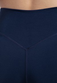 Leggings blu navy con vita alta, finitura testurizzata, cucitura a forma di V sul retro e dettagli di cucitura morbidi.