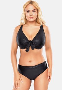 Fekete bikini szett, V-nyakú felső részével, középen masnival, és magas derekú alsó résszel. Az anyag finom fénylő hatású.
