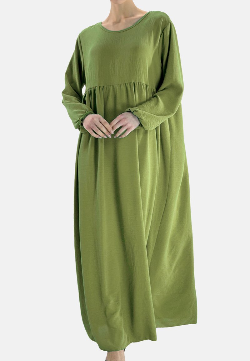 Lange mouwen, groene jurk tot op de knie, gemaakt van lichtgewicht stof. Voorzien van een gerimpelde taille en een losse pasvorm met een ronde halslijn.