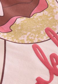 Lyserødt stof med et brunt donut-design, dekoreret med pink glasur og gyldne glimmerdetaljer. Inkluderer ordet "lækkert" i tekstureret rød skrift.