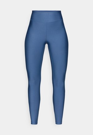 Högmidjade leggings av mjukt, elastiskt tyg i en djup blå färg, med en sömlös design och kroppsnära passform.