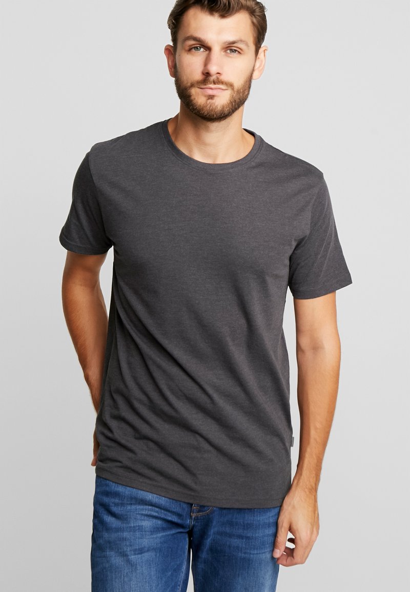 Grå bomull T-skjorte med korte ermer og rund hals; avslappet passform, glatt tekstur, synlige sømmer, kombinert med blå denimjeans.