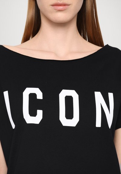 T-shirt noir avec un large décolleté et le mot "ICON" en lettres majuscules blanches sur le devant. Texture de tissu douce et lisse.