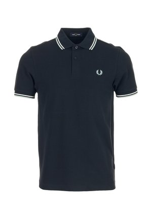 Polo noir à manches courtes avec double bandes blanches au col et aux poignets, patte à deux boutons et petit logo laurier brodé sur la poitrine.