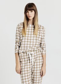 Completo da casa in fantasia pied de poule marrone e bianca. Maglia a maniche lunghe e pantaloni coordinati con vita regolabile e tessuto morbido.