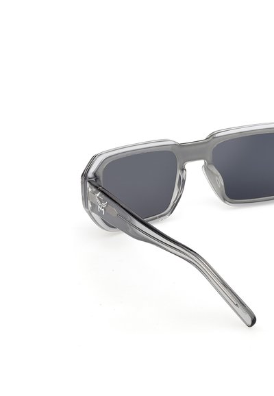 Gafas de sol rectangulares transparentes en color gris con lentes oscuras, montura gruesa y patillas ligeramente curvadas, mostradas sobre fondo blanco.