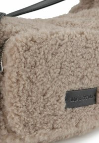 Borsa in ecopelliccia beige con superficie testurizzata, chiusura con zip e etichetta in pelle nera con il nome del marchio.