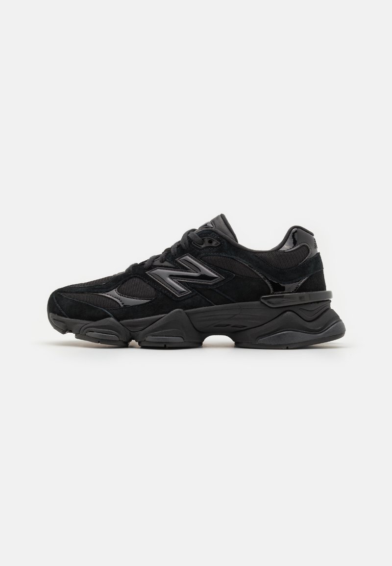 Baskets noires New Balance avec empeigne en mesh et en daim, semelle épaisse et logo "N" sur le côté, présentées sur fond blanc.