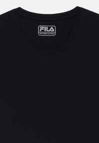 Melns īsām piedurknēm T-krekls, izgatavots no kokvilnas. Tam ir apaļa kakla izgriezne un iekšpusē ielocīta "FILA" logo etiķete. Gluda tekstūra un vienkāršs dizains.