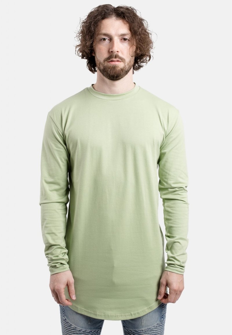 Lange mouwen, lichtgroen t-shirt van zachte stof. Heeft een ronde hals, aansluitende mouwen en een gebogen zoomontwerp.