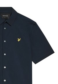 Camicia corta blu navy in cotone; presenta un logo ricamato di un'aquila gialla sul petto e colletto con bottoni.