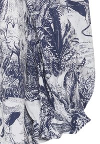Il tessuto a motivo blu navy e bianco presenta un design botanico con un mix di foglie e fenicotteri. La struttura appare leggera e leggermente stropicciata.