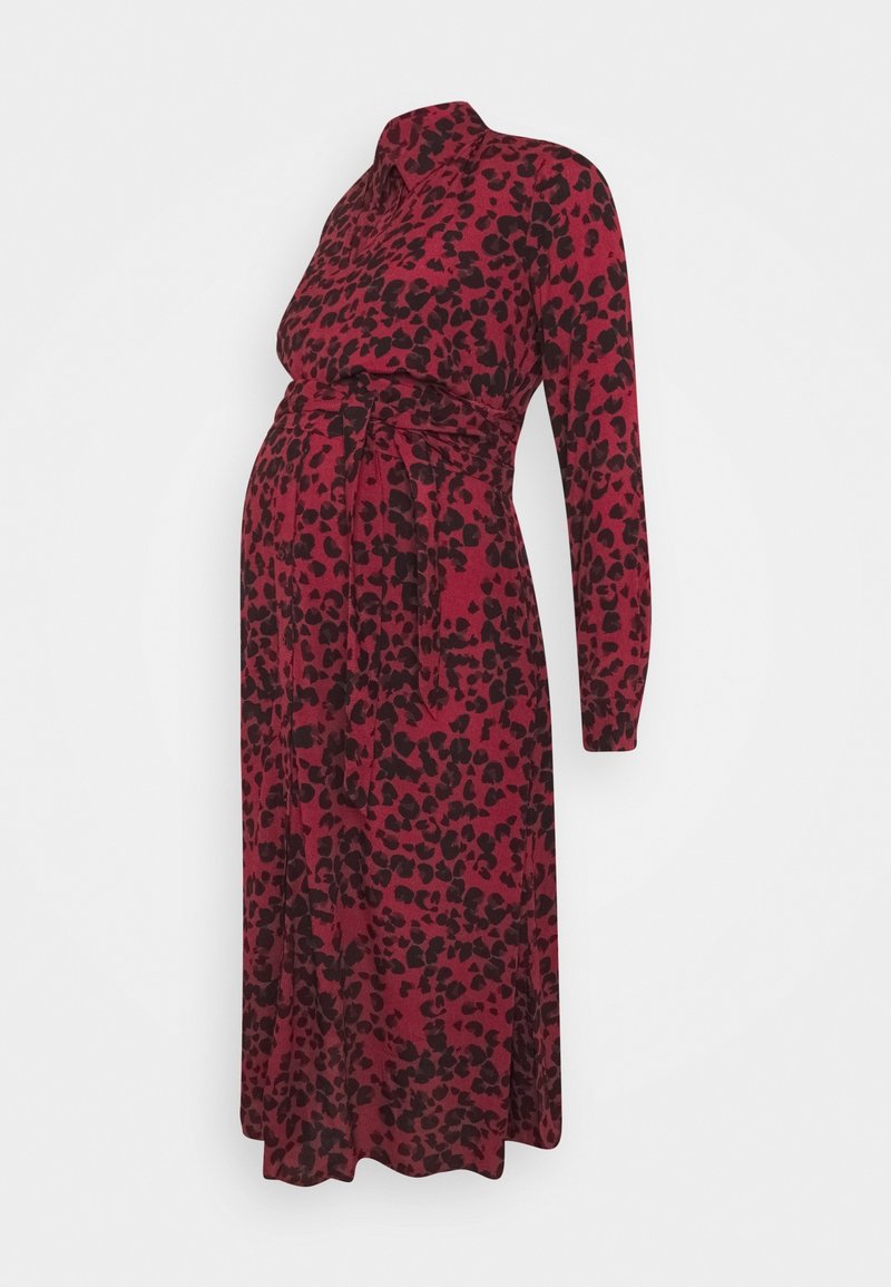 Robe de maternité à manches longues bordeaux avec des taches noires abstraites, col à revers et ceinture à nouer à la taille.