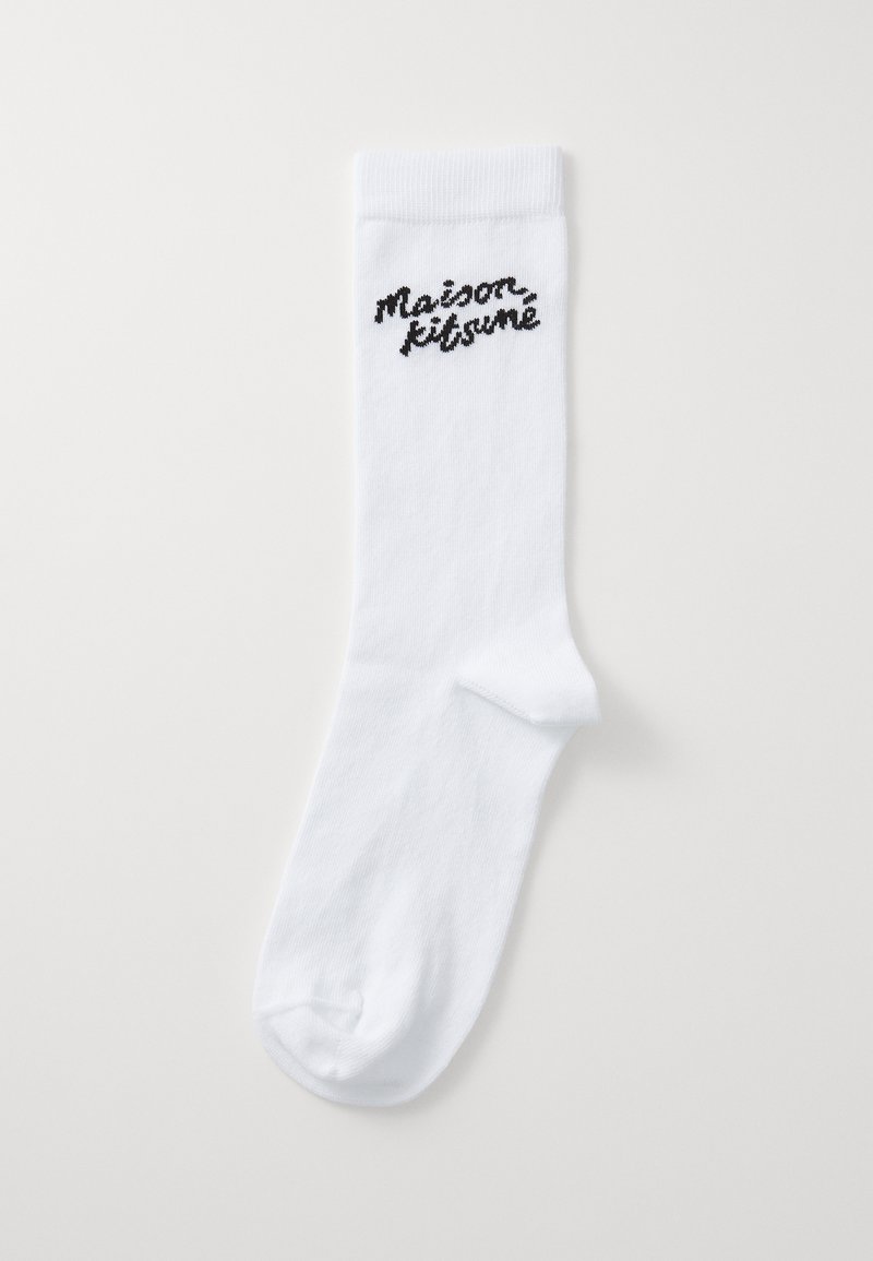 Bela bomba iz bombažnih nogavic z rebrastim robom in vezenim črnim logotipom "maison kitsuné" blizu vrha. Gladka tekstura, standardna dolžina do gležnja.