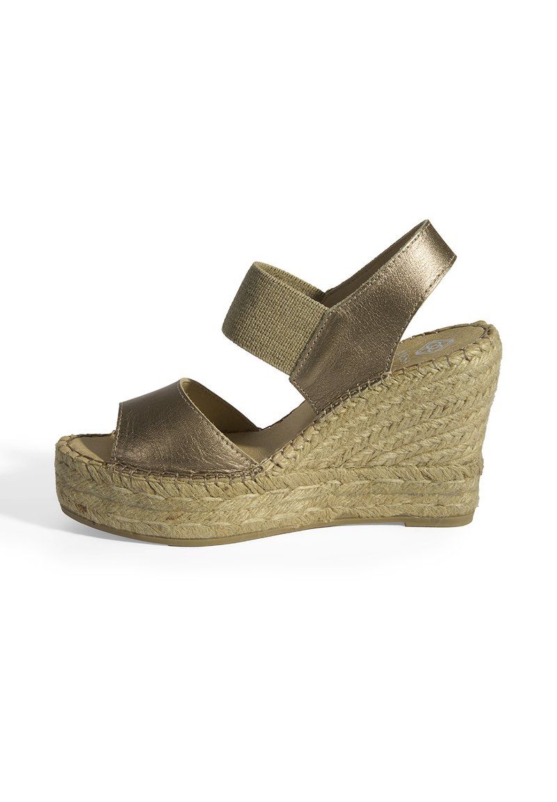 Sandale en bronze avec un design peep-toe, une bride élastique et une plateforme en jute tissé. Fini métallique lisse et bases texturées.