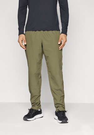 Olijfgroene sportbroek met een taps toelopende pasvorm en een elastische tailleband. Voorzien van ritszakken aan de zijkant en een soepele, lichte stof.