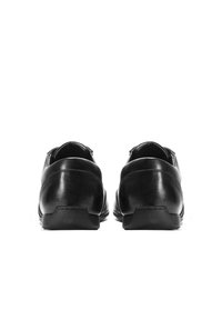 Čierne kožené mokasíny s hladkou textúrou, zaobleným opätkom a jemnými švami. Dizajn je jednoduchý a minimalistický.